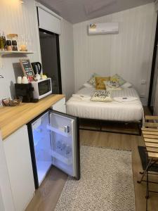 AmamoorTiny House Elevation 156-2的小房间设有床铺和微波炉