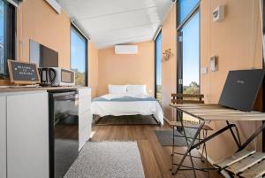 亚拉腊Montara Views 4的客房设有一张床、一张桌子和一台笔记本电脑