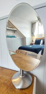 温德米尔Invergarry Room Only Guest House For Adults的卧室内的圆形镜子,配有床