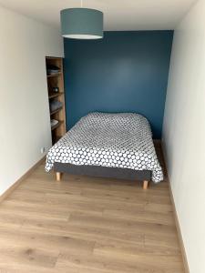 RougemontAppart的一间卧室设有一张床和蓝色的墙壁