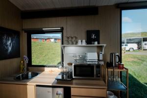RuawaroMighty Tiny House 2的厨房配有微波炉、水槽和窗户。