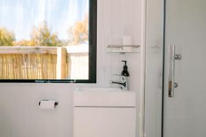 蒂阿瑙Harrington's on the Terrace - Murchison的白色的浴室设有水槽和窗户。
