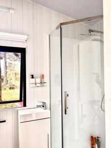 RangihaeataAroha Tiny House的带淋浴和盥洗盆的白色浴室