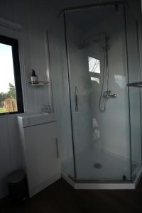 凯塔亚Breathe Inn的一间带玻璃淋浴和水槽的浴室