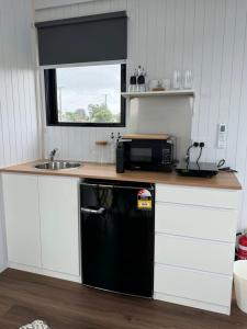 Otaki BeachRangiuru Stream Tiny home的厨房配有黑色微波炉和水槽