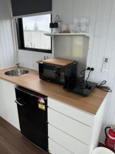 Otaki BeachRangiuru Stream Tiny home的带微波炉和水槽的小厨房