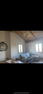 Villa dʼAianoVilla Franca casa immersa nel verde的客厅配有沙发和墙上的时钟