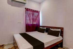 戈勒克布尔OYO Flagship Pragati Resort Marriage Hall & Restaurant的红色窗户的房间里一张床位