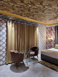 巴雷利Bellazio Suites Hotel & Resort的一间卧室配有一张床和一张玻璃桌子及椅子