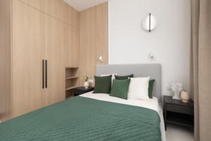 什切青JTB Brama Portowa的一间卧室配有绿色和白色的床和橱柜。
