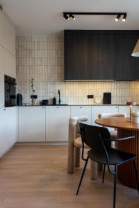 乌斯特龙Apartament Olchowa的厨房配有白色橱柜和桌子