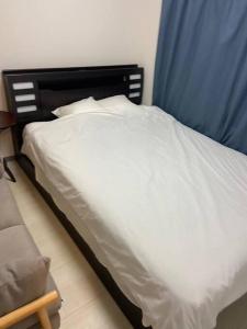 东京tokyo Large family vacation rentals的一张带白色床单和蓝色窗帘的床