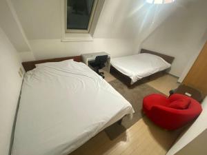 东京tokyo Large family vacation rentals的小房间设有一张床和一把红色椅子