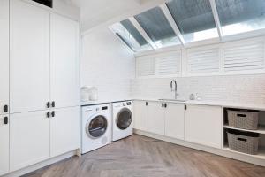 Curl CurlCurley Sunrise - Oceanfront的白色的厨房配有水槽和洗衣机