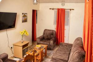 EmbuHilda's place的客厅配有沙发、椅子和电视