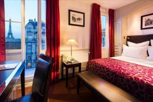 巴黎迪尤肯埃菲尔酒店的配有一张床、一张书桌和一扇窗户的酒店客房
