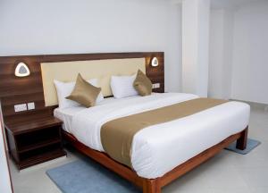 埃尔多雷特The Grand Rocks Hotel Limited的一间卧室配有一张大床和木制床头板