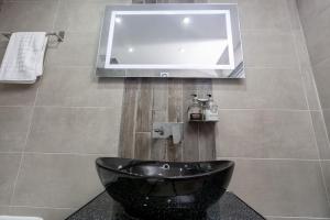 布莱克浦2bdr house - close to seafront的浴室设有黑色水槽和镜子