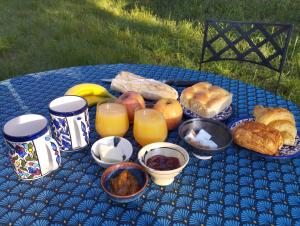 阿莱斯La yourte kirghize的蓝色桌子,上面有不同类型的面包和橙汁