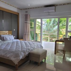利隆圭Mpatsa Quest Hotels的一间卧室设有一张大床和一个大窗户