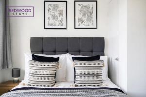 法恩伯勒Cozy 3 Bed House with X2 FREE Parking By REDWOOD STAYS的一间卧室配有一张带两个枕头的床