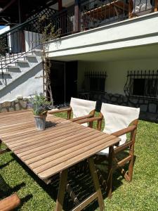 尼基季Perfect Hospitality - Elenas House, Nikiti的一张木餐桌,在草地上摆放两把椅子