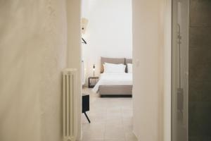 莱切Mediterranee Suite的一间白色的卧室,配有床和散热器