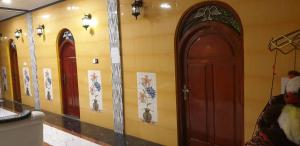 贾夫纳Gabriel Lanka Hotel (PVT) LTD的一间设有两扇门的房间,墙上挂着绘画作品