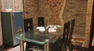 贾夫纳Gabriel Lanka Hotel (PVT) LTD的一张餐桌,配有玻璃桌和椅子