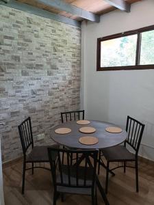 佩诺诺梅La Amistad agrotourism farm的砖墙房里的桌椅