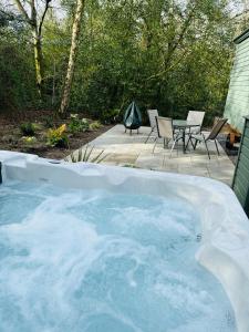 杜伦Southfield Shepards Huts的后院的热水浴池配有椅子和桌子