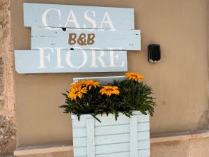滨海波利尼亚诺卡萨菲奥雷住宿加早餐酒店的白色木板条,花标和橙色花