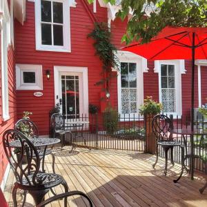 弗雷德里克顿The Red House Fredericton的木制甲板上设有桌椅的红色房子