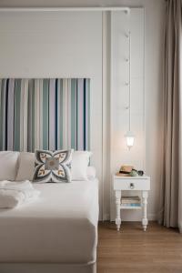 卡托利卡Luxor Cattolica Beach Hotel的白色卧室配有白色的床和床头柜