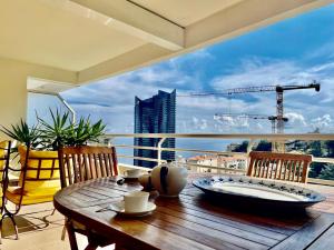 博索莱伊2 Rooms In Luxury Residence Bordering Monaco的阳台的桌子,享有建筑的景色