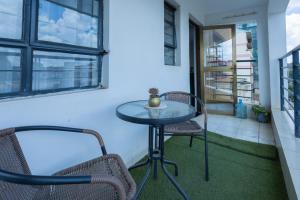 内罗毕Furnished 1 Bedroom Apartment in Nairobi. 15 Mins to CBD. Free WI-FI & Parking的阳台配有一张小桌子和两把椅子