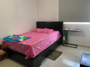 巴耶杜帕尔Don carmelo的卧室配有一张粉红色的床和一张桌子