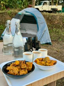 马迪凯里Shrenya Orchidz-Coorg Nature Stay的一张桌子,上面有一盘食物和帐篷
