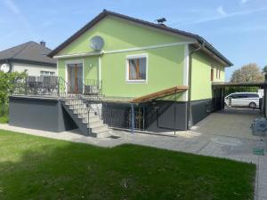 维也纳AJO Vienna Ambassador Family House with Free Parking的绿色房子,设有门廊和车道