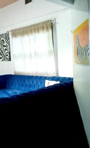 基苏木Monalissa One bedroom apartment的窗户客房内的蓝色沙发