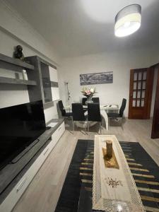 阿尔马达Quarto Suite Relaxante的客厅配有大电视和桌子