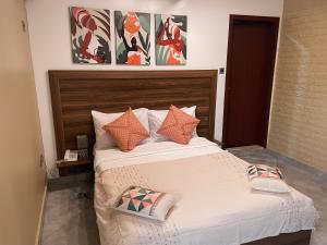 阿克拉Sky Suites Osu的一间卧室配有一张带橙色枕头的大床