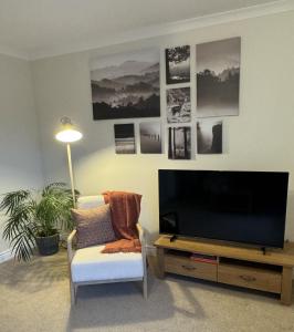 奥本Island View - Spacious Two Bedroom Oban Apartment with Sea Views的客厅配有平面电视和椅子。