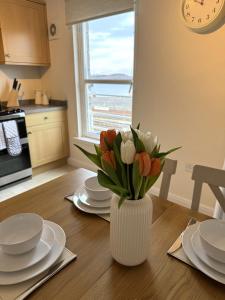 奥本Island View - Spacious Two Bedroom Oban Apartment with Sea Views的厨房里桌子上的一瓶郁金香