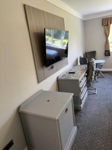 伍斯特梨树旅馆和乡村酒店的配有电视、书桌和桌子的客房