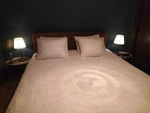 康塞普西翁新镇Bed & Breakfast Casa Sinne的一张带白色床单的床和枕头及两盏灯