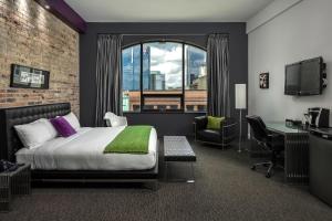 伦敦都会酒店的配有一张床、一张书桌和一扇窗户的酒店客房