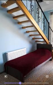 科布列季Apart townhouse的楼梯下面的红色床楼梯