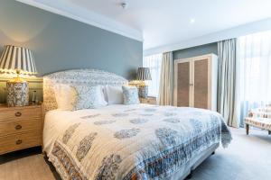 霍舍姆The Vineyard Hotel的蓝色的卧室设有一张大床和一个窗户
