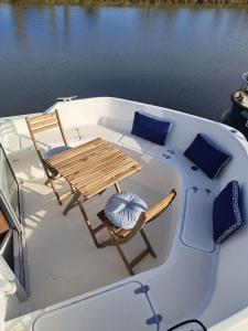 BazollesBATEAU - CANAL DU NIVERNAIS NIEVRE的船上的一张桌子和一把椅子